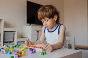 3 year old boy is immersed in his own world. Child obsession with numbers and counting. Manifestation of autism in children